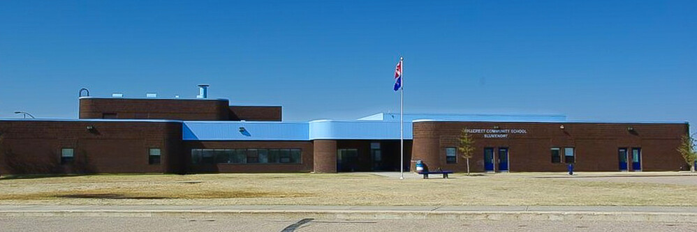dark brick school building with blue roof
