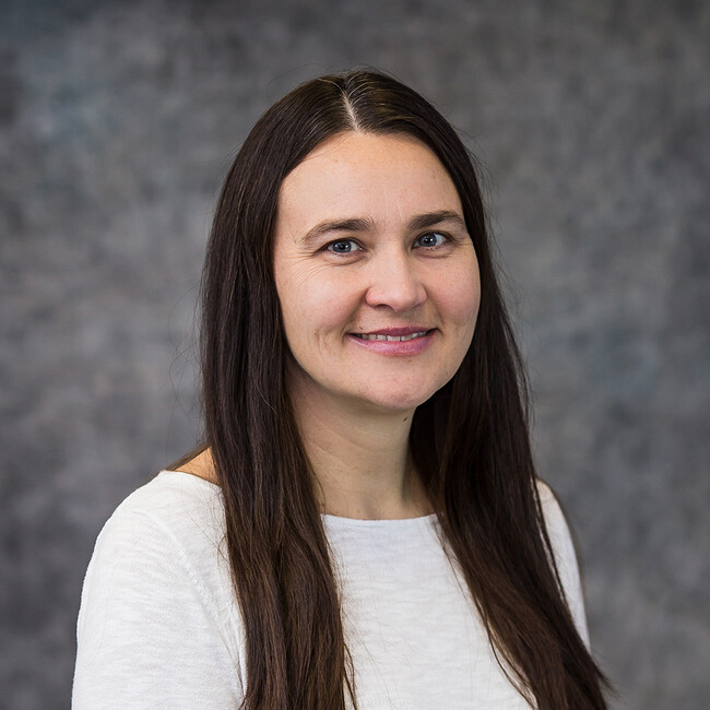 woman with long straight dark hair smiling for the camera