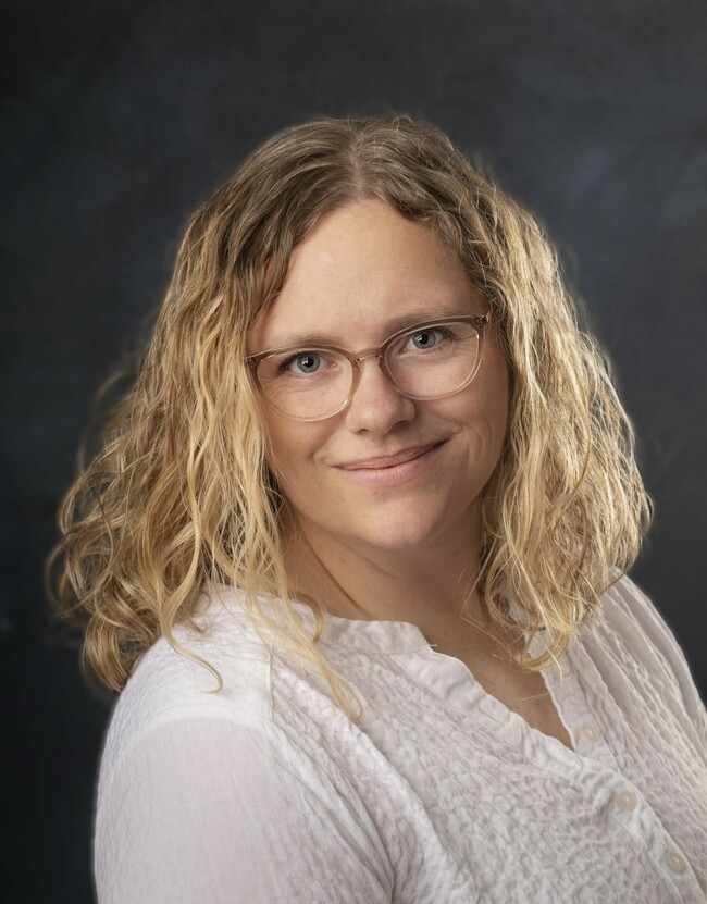 woman with long wavy blonde hair smiling for the camera