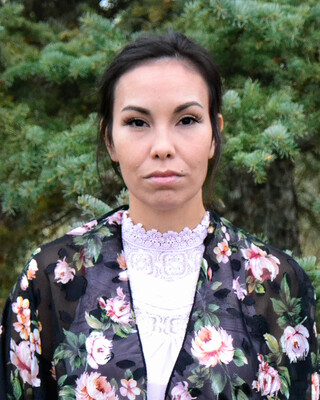 woman with black hair tied back wearing a flowered blouse