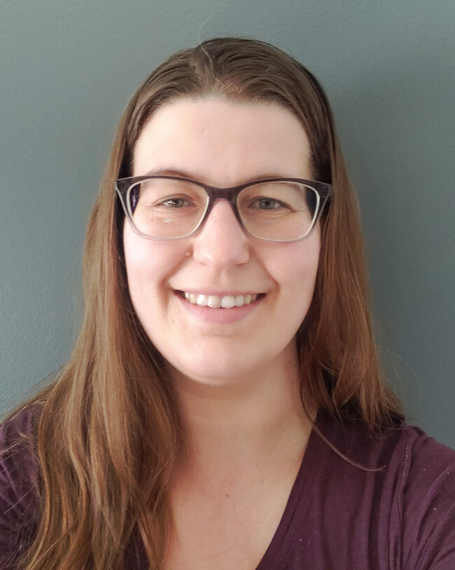 woman in glasses smiling for the camera