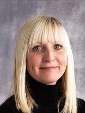 woman with shoulder length blonde hair wearing black turtleneck