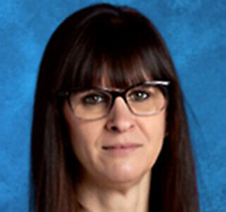 woman with long straight dark hair and glasses smiling for the camera