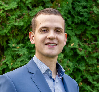 young man in a suit smiling for the camera