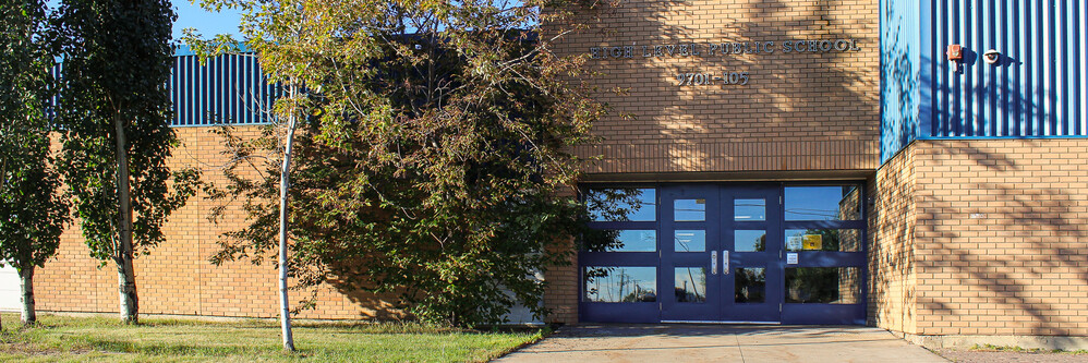 brick school building entrance with blue double doors
