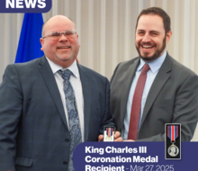 two men smiling and posing for the camera as one presents the other with a medal