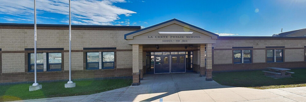 brick school building entrance under a bright blue sky