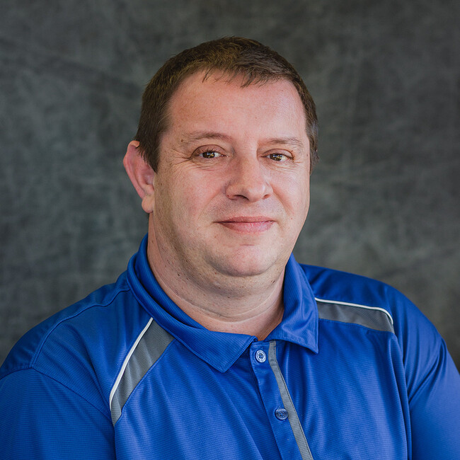 man in blue polo shirt smiling for the camera