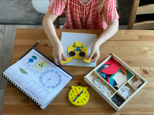 top down view of a child working on lessons at a wooden table