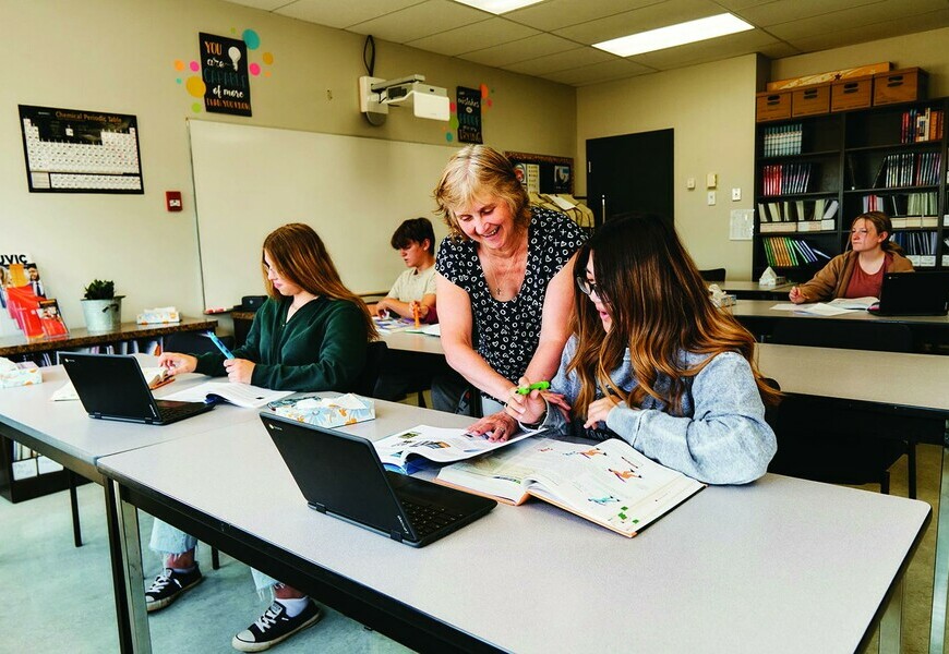 Teacher helping student in classroom