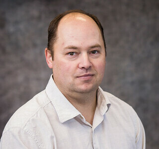 man wearing a white button up shirt posing for the camera