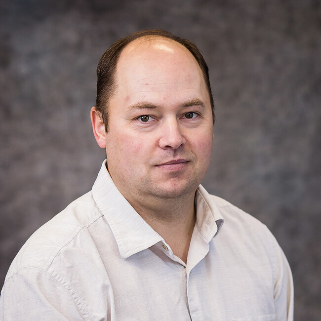 man wearing a white button up shirt posing for the camera