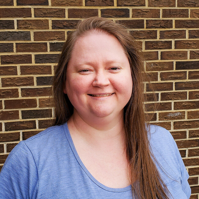 woman with long straight blonde hair smiling for the camera