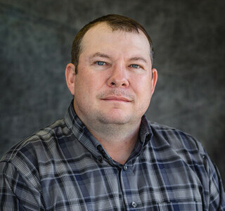 man in plaid shirt posing for the camera