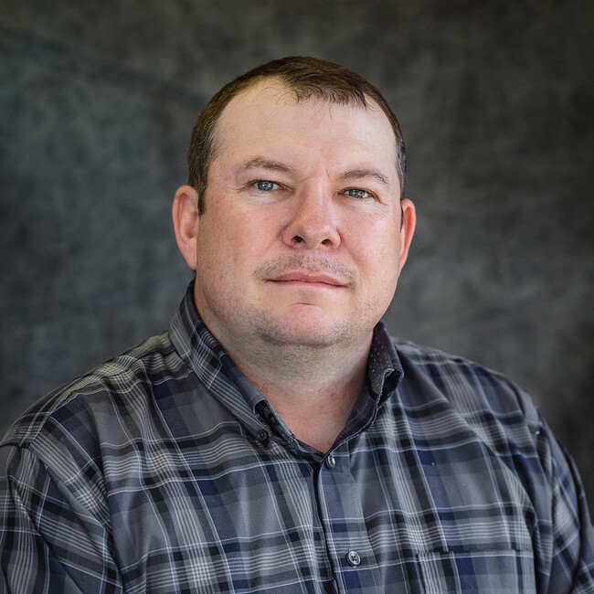 man in plaid shirt posing for the camera